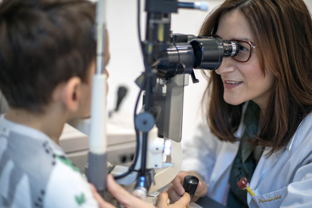 La Dra. Carmen Hernández explorando la vista de un niño en consulta de control de miopía