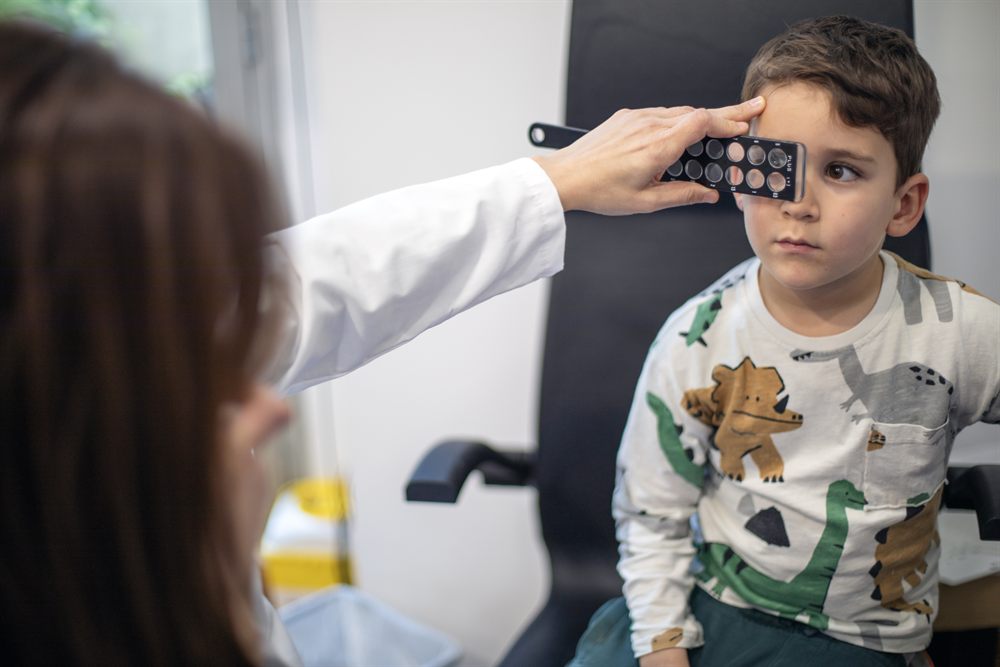 La Dra. Carmen Hernández tapando un ojo a un niño durante la exploración del ojo vago